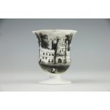 An early 19th century egg cup, transfer printed in black with a scene of a gate house or castle,