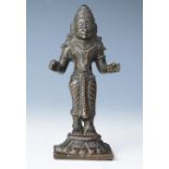 A cast bronze figure of a deity, standing upon a lotus flower,