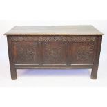 An 18th century oak coffer, with later carved detailing, on stile feet,