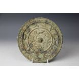 A Chinese bronze mirror, Tang Dynasty style, cast with dragons and animals with calligraphy border,