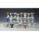 A collection of twenty four 19th century and later egg cups,