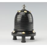 An Edwardian ebony bee hive shape vesta and go-to-bed, raised on three stilt feet,