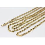 A yellow metal long guard chain with attached swivel stamped '18',
