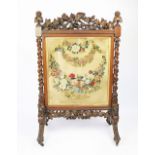 A Victorian carved oak fire screen,