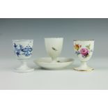 A 19th century Meissen porcelain egg cup and integral base, painted with roses,