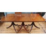 A Regency style cross banded mahogany triple pillar dining table,