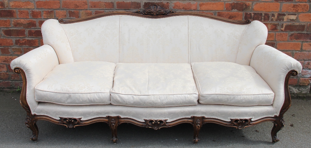 A French Louis XVI style carved and stained walnut salon suite, with floral ivory upholstery,