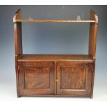 An Edwardian oak hanging shelf, with two cupboard doors,