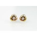 A pair of tri-colour gold and diamond set stud earrings,