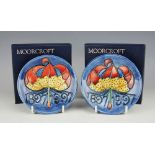 A pair of Moorcroft Centenary pin dishes, plate 1897-1997, each decorated with a lily and dates,