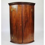A George III mahogany bow front corner cabinet,