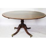 A Regency mahogany oval tilt top table, with turned column, on reeded out swept legs,