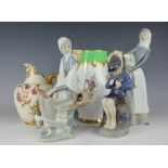 A Copenhagen figure of a seated boy carving, with two Lladro figures, tallest 27cm high,