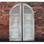 A pair of Continental painted wood window shutters, for an arched aperture,