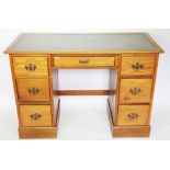 An early 20th century light oak pedestal desk, with an arrangement of seven drawers, on plinth base,