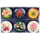 A collection of six Moorcroft pin dishes comprising; Hibiscus against a green ground,