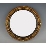 A Regency style gilt painted convex circular wall mirror, decorated with applied spheres, 24.