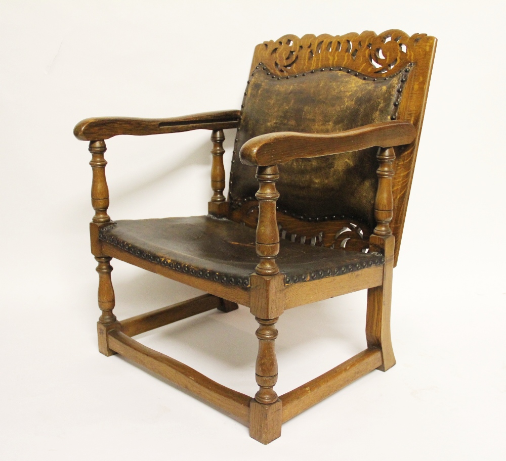 An early 20th century golden oak monks bench / seat, the pierced back with crown detailing,