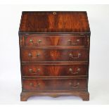 A 1920's mahogany bureau, the fall enclosing a compartmented interior with leather insert,