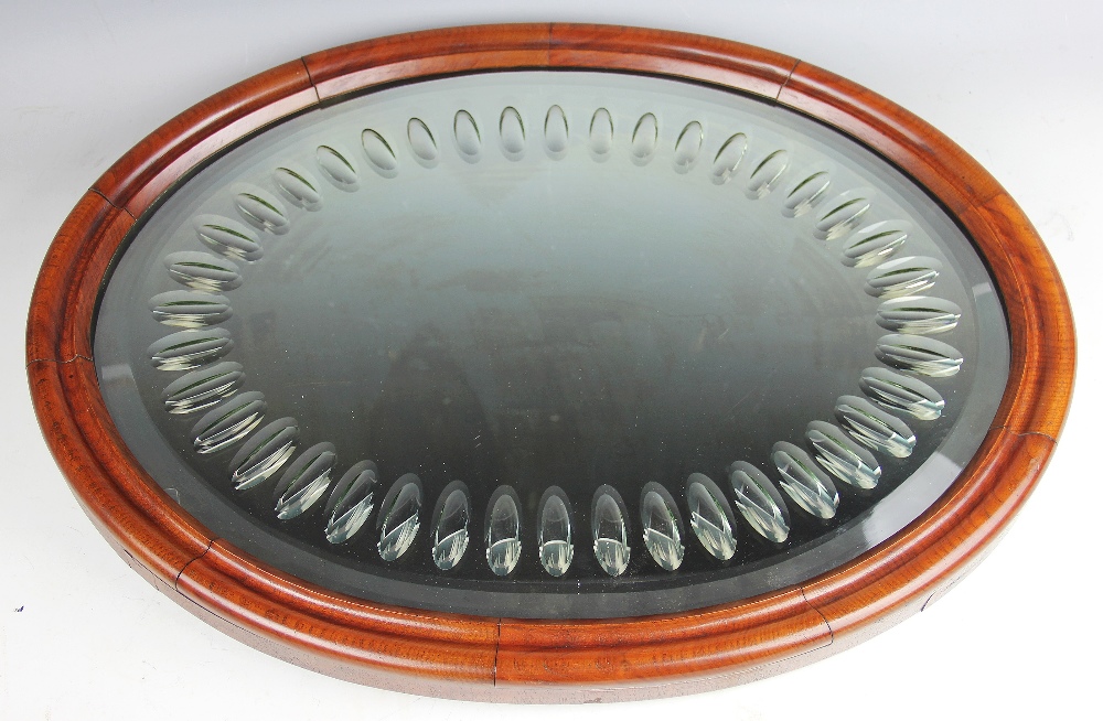 A late Victorian walnut oval wall mirror, the beveled plate with oval concave detailing,