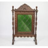 A Victorian carved oak fire screen, with green glass insert, 97cm H x 65cm W,
