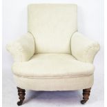 A pair of Edwardian club type chairs, with beige upholstery, on turned legs and fitted casters,