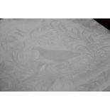 Four white damask table cloths, comprising one decorated with game birds and flowers,