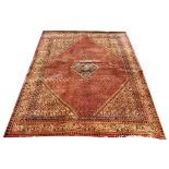 A Persian Sarouk wool carpet, worked with a design of small leaves in red and gold,