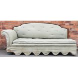 An early 20th century day bed, with show frame back and green upholstery, on block legs,