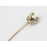 A diamond set horseshoe stick pin, set with seven graduated old cut diamonds,