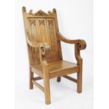 A carved pitch pine Bishops type chair, with Gothic panelled back and solid seat, on square legs,
