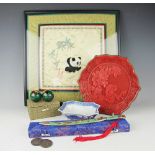 A selection of oriental wares to include a cinnabar lacquer plate, a silk embroidered panel,