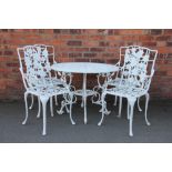 A painted metal garden table and four chairs, with pierced foliate detailing,