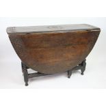 A late 17th century oak gate leg table, with long sword drawer and later carved detailing,