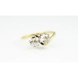 A two stone diamond ring, the two old, mixed cut diamonds within cross-over setting,