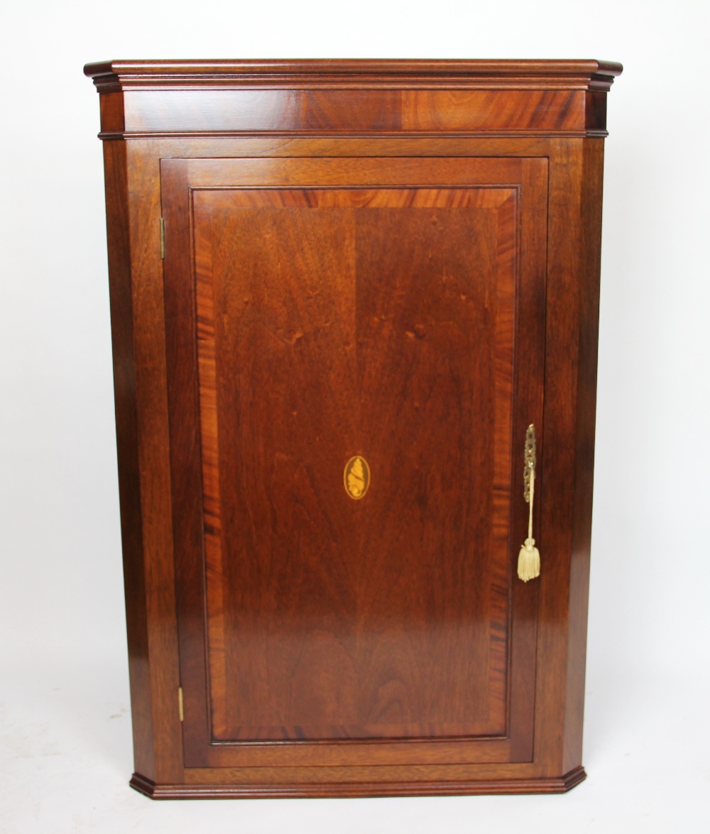 A George III style inlaid mahogany corner cabinet,