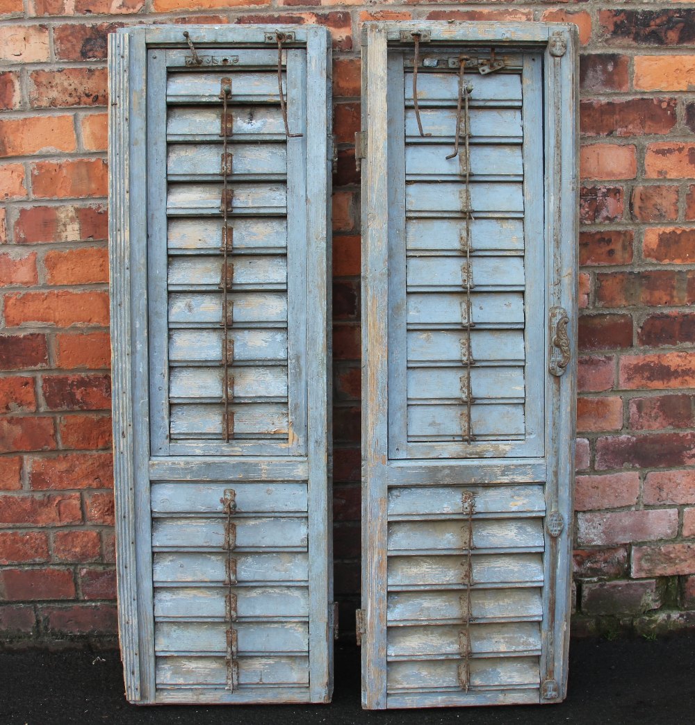 A pair of 19th century French grey painted rustic slatted window shutters, with cast iron furniture,