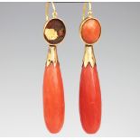 A pair of coral coloured drop earrings,