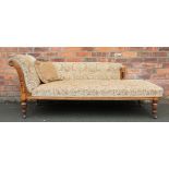 A late Victorian golden oak chaise longue, with button back golden floral upholstery,