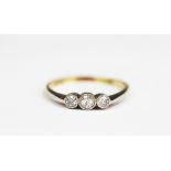 A three stone diamond ring, the three graduated diamonds, each within millegrain collet,