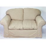 A white upholstered two seater settee, with removable beige covers,