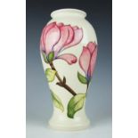 A large Moorcroft Magnolia pattern vase, decorated with pink flowers against an ivory ground,