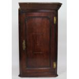 A George III oak hanging corner cabinet, with star inlaid door,