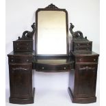 A Victorian carved mahogany bow front dressing table with three drawers and two cupboard doors on