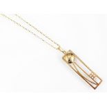 A 9ct yellow gold Rennie Mackintosh inspired peandant and attached fine chain,