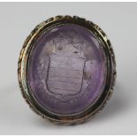 An amethyst intaglio set ring (converted from a seal) engraved family crest and motto 'Palmam