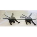 A modern bronze and glass coffee table, the glass top with a bevelled edge and canted corners,