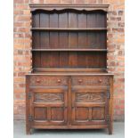 A 1920's oak dresser, with plate rack and two drawers, above two cupboard doors,