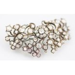 A Victorian diamond set brooch, designed as a central ten stone diamond circular cluster,