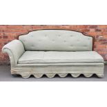 An early 20th century day bed, with show frame back and green upholstery, on block legs,